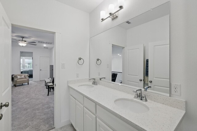 ensuite bathroom with double vanity, a sink, ensuite bath, and visible vents