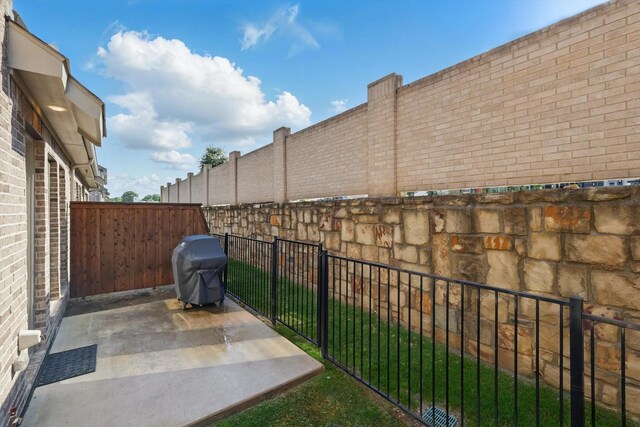 view of patio with grilling area and a fenced backyard