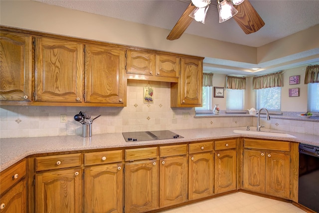 kitchen featuring black appliances, brown cabinets, light countertops, and a sink