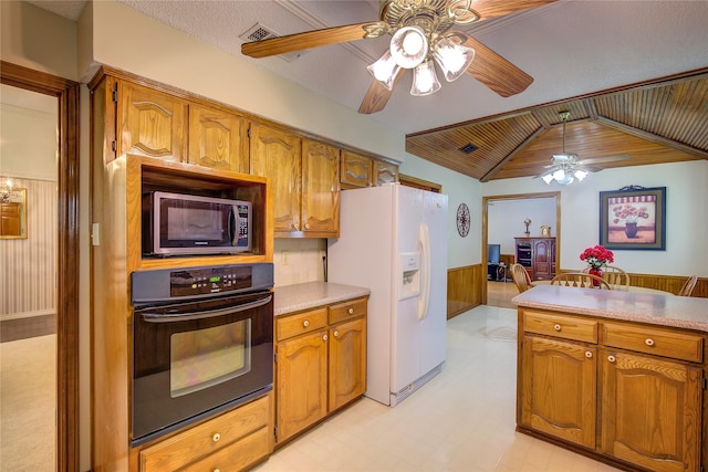 kitchen featuring white fridge with ice dispenser, stainless steel microwave, black oven, ceiling fan, and wainscoting