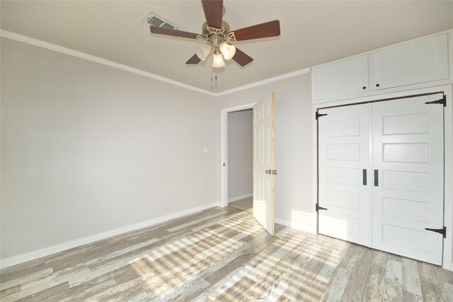 216 S Mesquite St, Muenster, TX 76252 - unfurnished bedroom featuring crown molding, visible vents, a closet, light wood-style floors, and baseboards