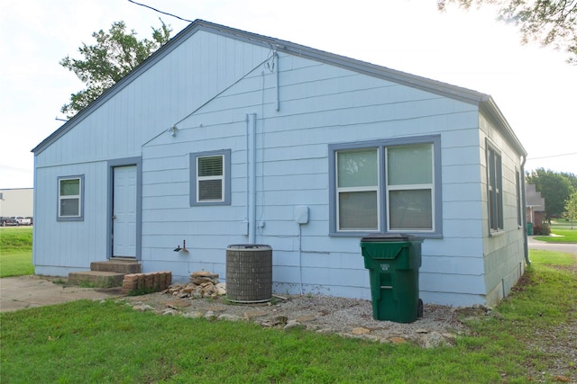 216 S Mesquite St, Muenster, TX 76252 - back of house featuring entry steps, central AC unit, and a lawn