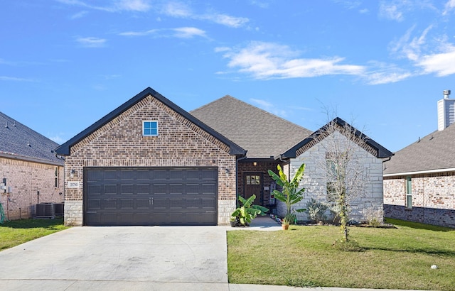 french country home featuring brick siding, stone siding, a front yard, concrete driveway, and an attached garage