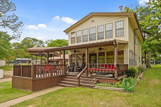 back of house featuring ceiling fan and a lawn