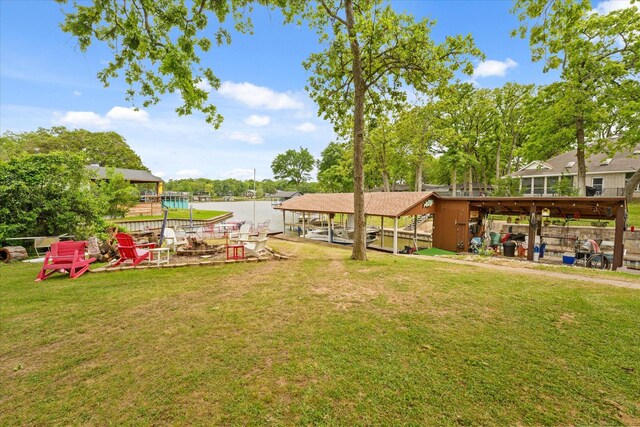view of yard with a water view, a boat dock, and boat lift