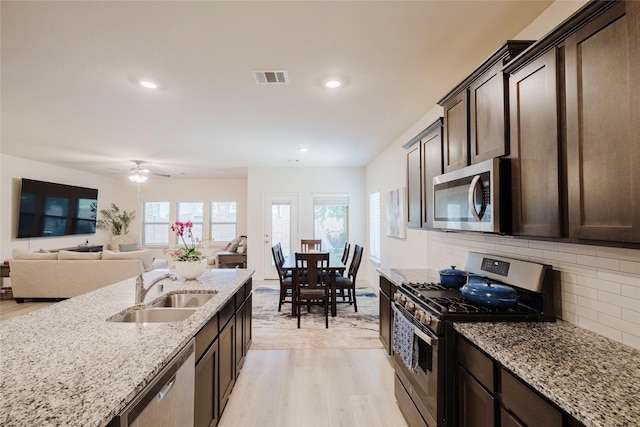 462 Pleasant Hill Ln, Fate, TX 75189 - kitchen featuring dark brown cabinets, appliances with stainless steel finishes, a sink, and light wood finished floors