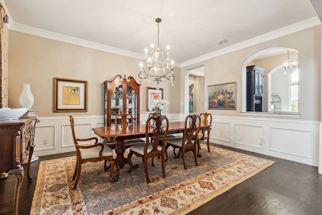 dining area featuring crown molding, visible vents, arched walkways, an inviting chandelier, and dark wood finished floors