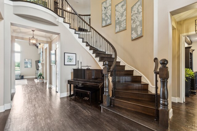 stairway featuring an inviting chandelier, wood finished floors, and baseboards