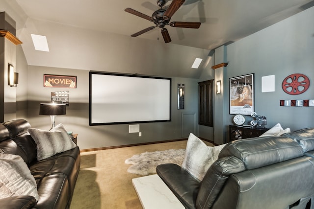 carpeted home theater room with ceiling fan, vaulted ceiling, and baseboards