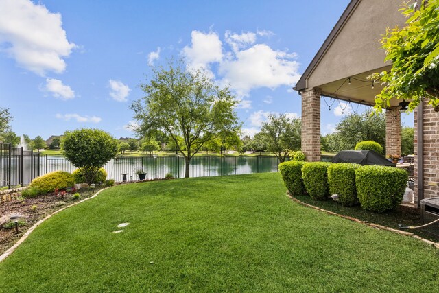 view of yard with a water view and fence
