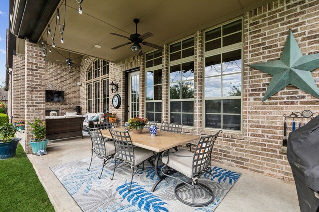 view of patio / terrace with outdoor dining space, ceiling fan, and an outdoor living space with a fireplace