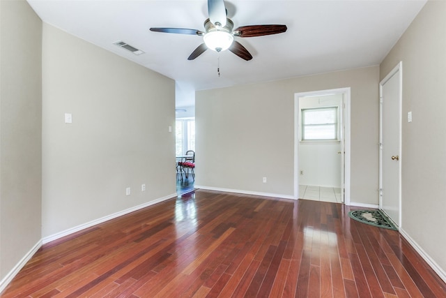 unfurnished room featuring ceiling fan, wood finished floors, and baseboards