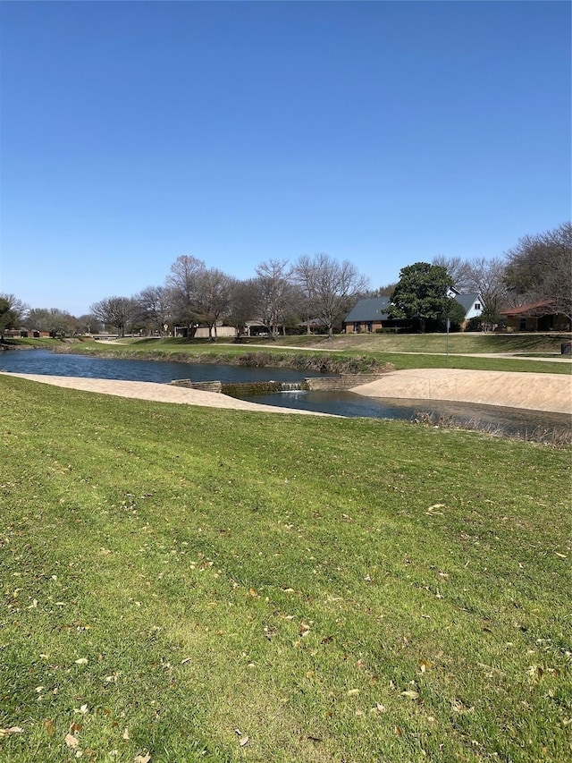 view of community with a yard and a water view