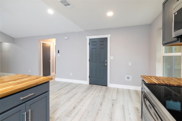 kitchen with wooden counters, light wood-style flooring, visible vents, baseboards, and appliances with stainless steel finishes
