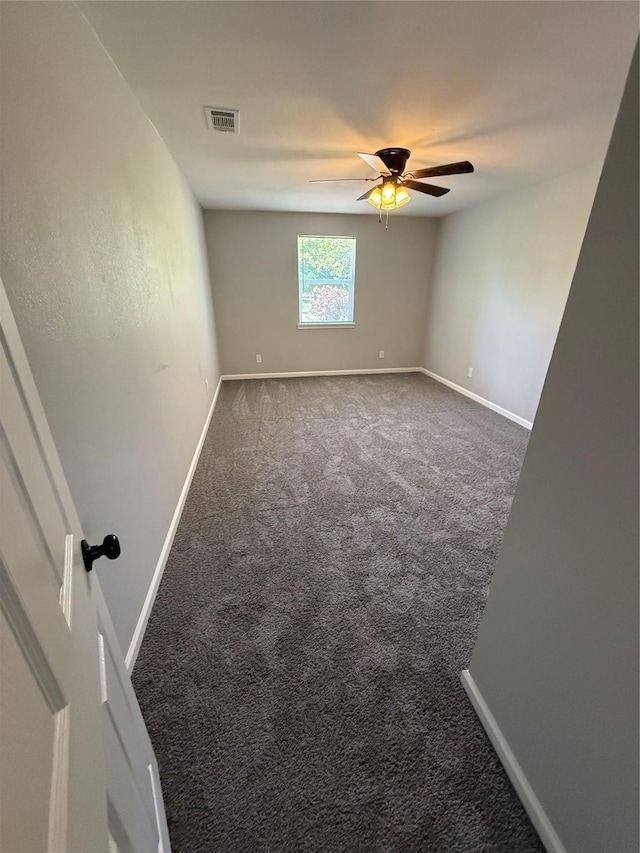 carpeted empty room with visible vents, ceiling fan, and baseboards