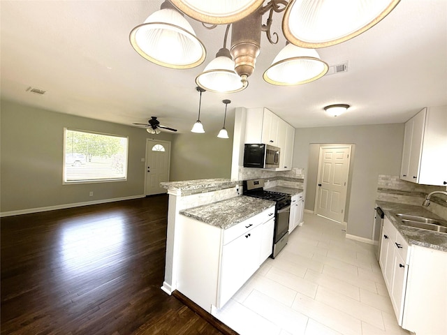 kitchen featuring baseboards, appliances with stainless steel finishes, decorative backsplash, and a sink