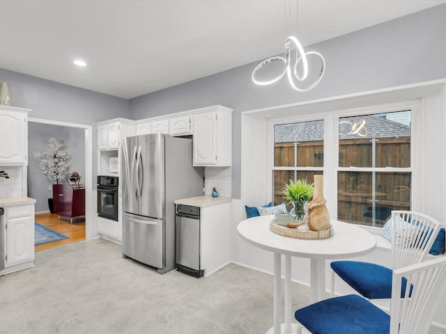 2024 Crestside Dr, Carrollton, TX 75007 - kitchen with oven, freestanding refrigerator, light countertops, white cabinets, and a chandelier