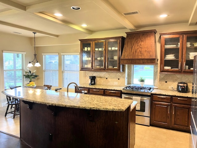 15100 Mount Evans Dr, Little Elm, TX 75068 - kitchen featuring stainless steel gas range oven, custom range hood, beam ceiling, decorative backsplash, and a breakfast bar