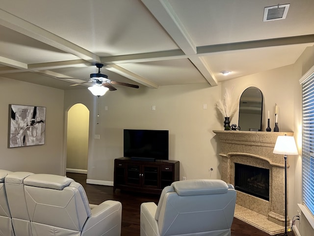 15100 Mount Evans Dr, Little Elm, TX 75068 - living area featuring dark wood-style flooring, a premium fireplace, beam ceiling, ceiling fan, and arched walkways