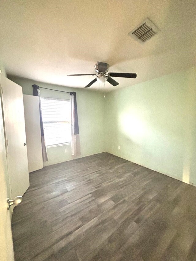 unfurnished room with visible vents, ceiling fan, and wood finished floors