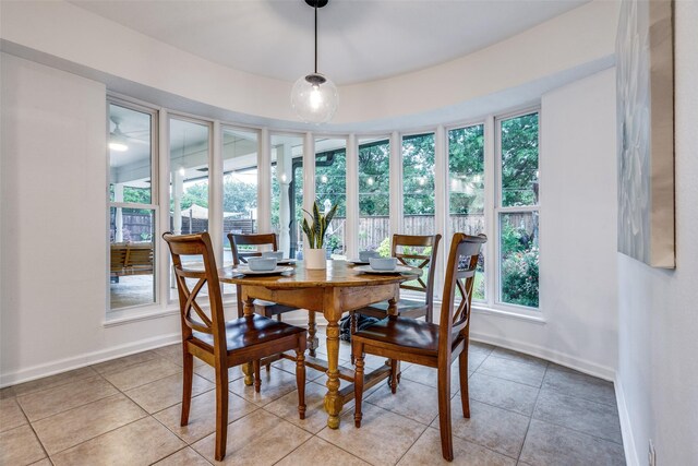 dining space featuring baseboards and light tile patterned flooring