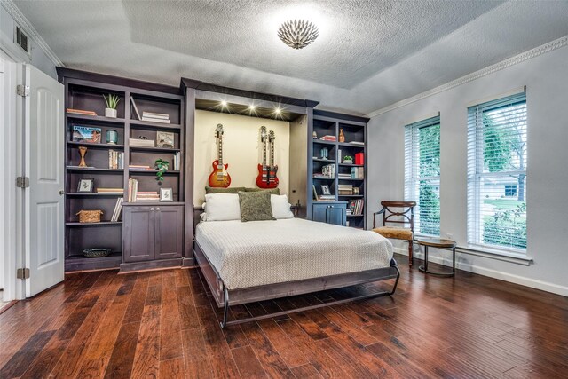 bedroom with baseboards, ornamental molding, dark wood-style floors, visible vents, and a textured ceiling