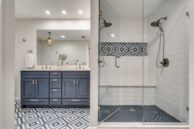 full bath featuring recessed lighting, double vanity, a sink, and a shower stall