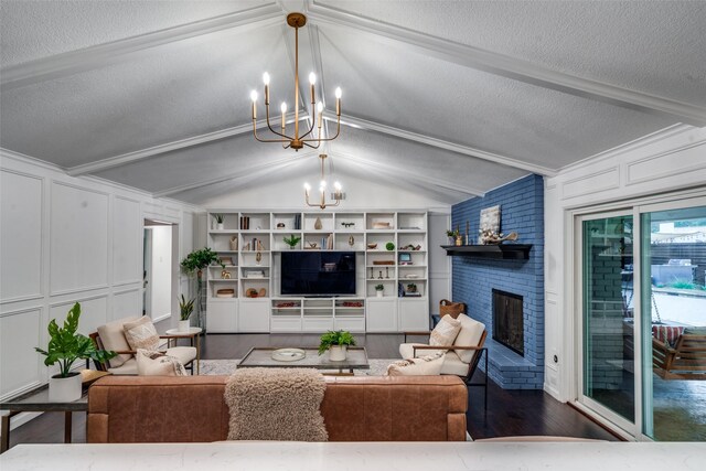 living room with a decorative wall, lofted ceiling with beams, an inviting chandelier, a brick fireplace, and wood finished floors