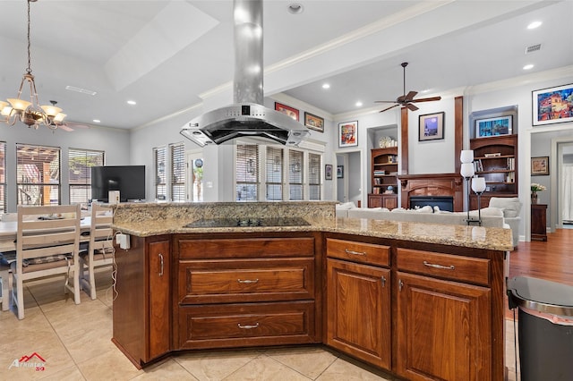 kitchen featuring ceiling fan with notable chandelier, open floor plan, island range hood, visible vents, and ornamental molding