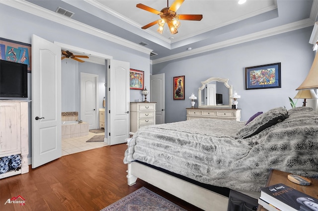bedroom featuring crown molding, a raised ceiling, wood finished floors, and visible vents