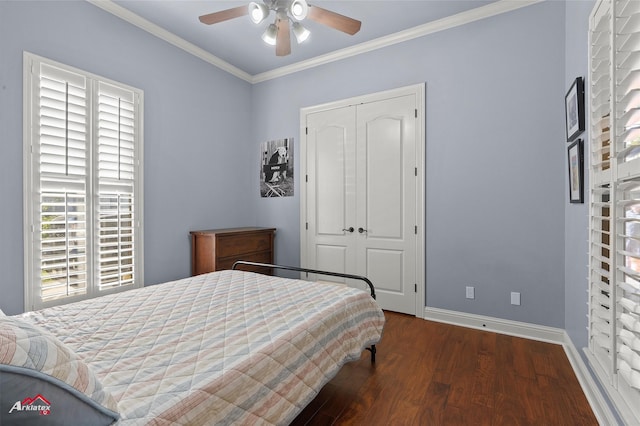 bedroom featuring a ceiling fan, crown molding, wood finished floors, baseboards, and a closet