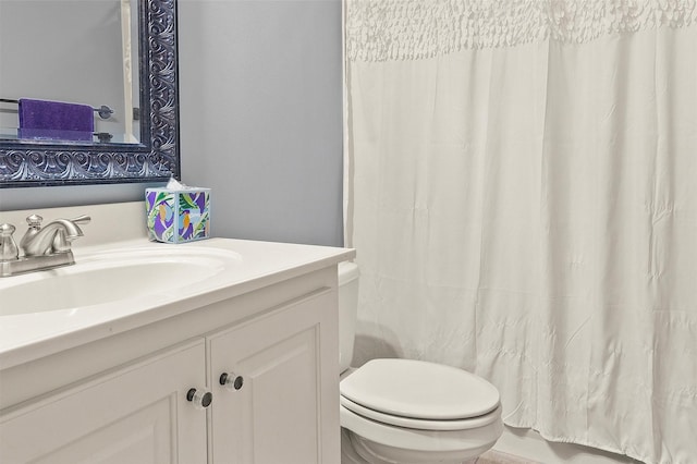 bathroom with vanity, shower / bathtub combination with curtain, and toilet
