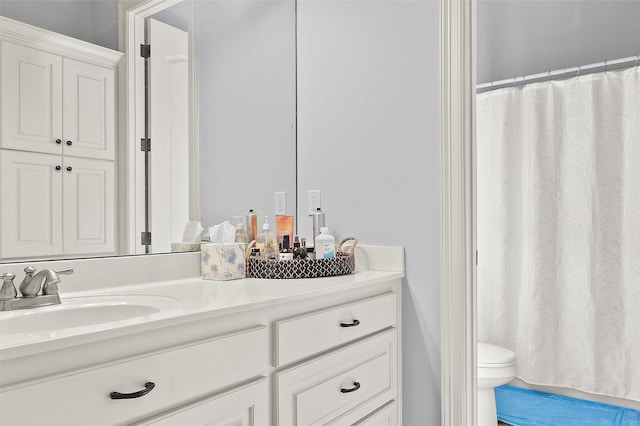 bathroom featuring toilet, a shower with shower curtain, and vanity