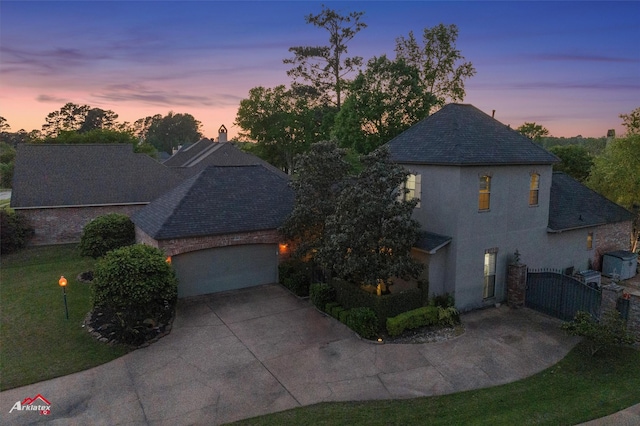 view of front facade featuring driveway, a gate, a garage, a shingled roof, and stucco siding