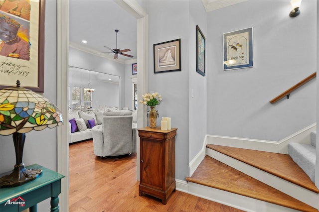 interior space featuring a chandelier, baseboards, light wood-type flooring, ornamental molding, and stairway