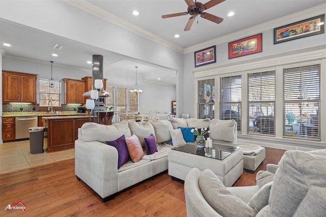 living area with ornamental molding, ceiling fan with notable chandelier, recessed lighting, and visible vents