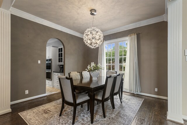 dining room featuring baseboards, arched walkways, a notable chandelier, and ornamental molding