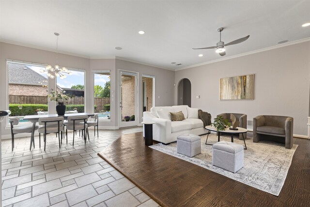 living room with crown molding, recessed lighting, and arched walkways