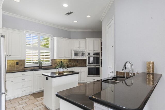 kitchen featuring a sink, dark countertops, backsplash, and stainless steel appliances