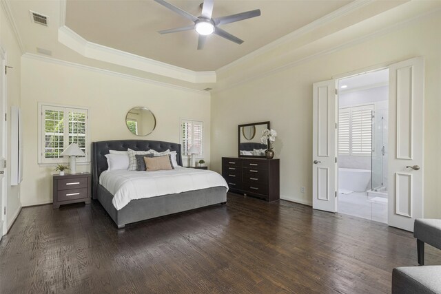 bedroom with dark wood-style flooring, a raised ceiling, ensuite bathroom, visible vents, and ornamental molding