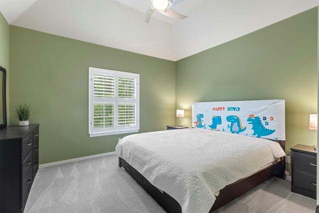 bedroom with light colored carpet, a ceiling fan, baseboards, and vaulted ceiling