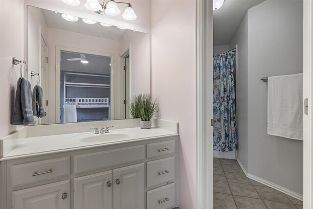 full bath featuring tile patterned floors, baseboards, vanity, and curtained shower