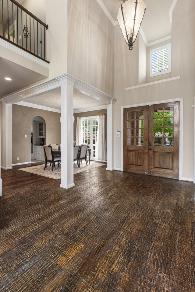 entryway with baseboards, decorative columns, french doors, and a towering ceiling