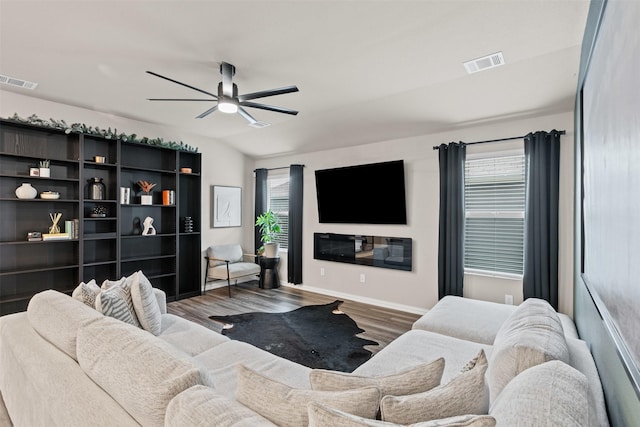 living area featuring wood finished floors, visible vents, and ceiling fan
