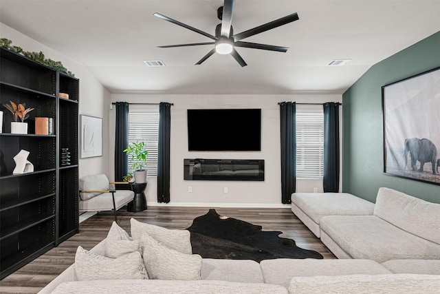 living room with visible vents, wood finished floors, a ceiling fan, and vaulted ceiling