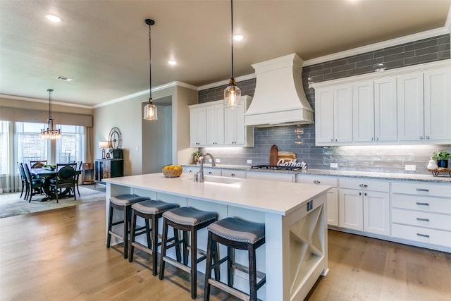 12492 Palmer Dr, Fort Worth, TX 76179 - kitchen featuring a sink, light countertops, decorative backsplash, custom range hood, and ornamental molding