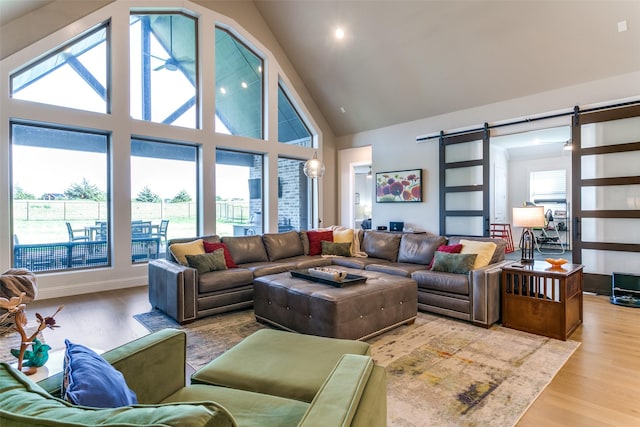 12492 Palmer Dr, Fort Worth, TX 76179 - living room with a barn door, wood finished floors, a wealth of natural light, and high vaulted ceiling