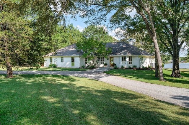 ranch-style home featuring a front yard and a chimney