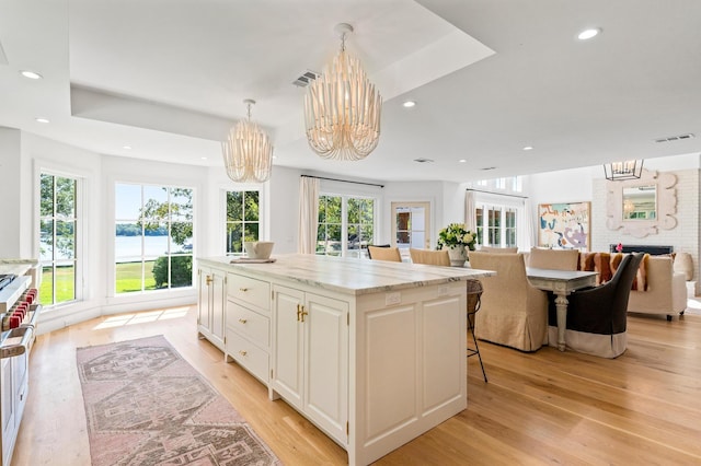 kitchen featuring open floor plan, a chandelier, a kitchen island, and visible vents