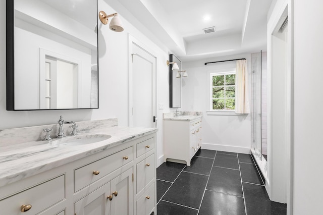 full bath featuring tile patterned floors, two vanities, visible vents, and a sink